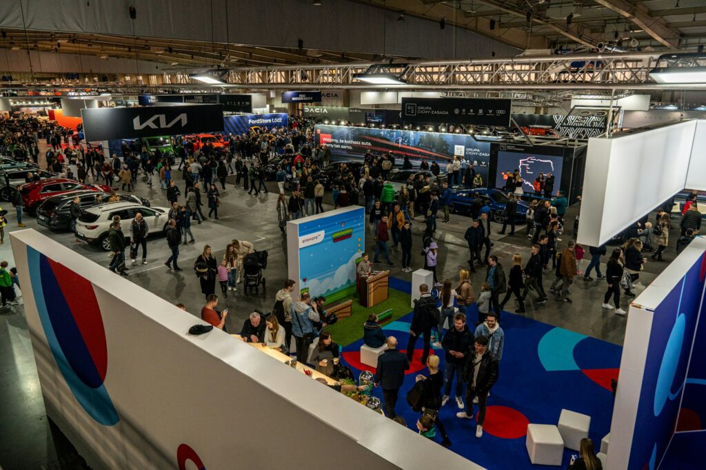 Multitud en un salón del automóvil con vehículos en exhibición